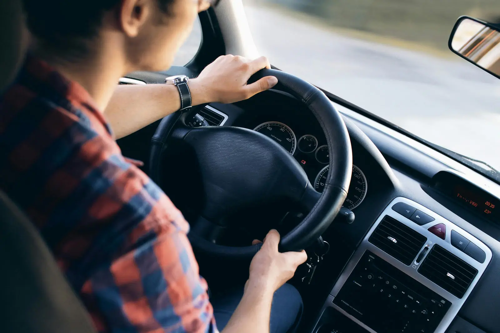 dettagli di un interno di auto con una ragazza alla guida
